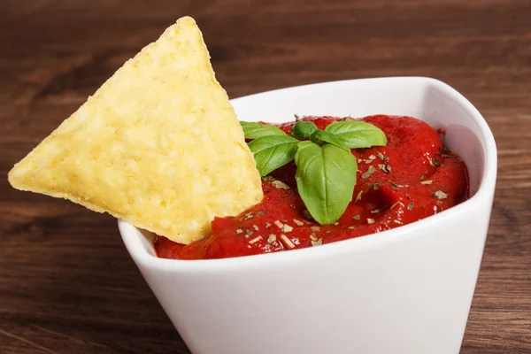 Salted potato crisps and sauce in bowl on board, concept of unhealthy food