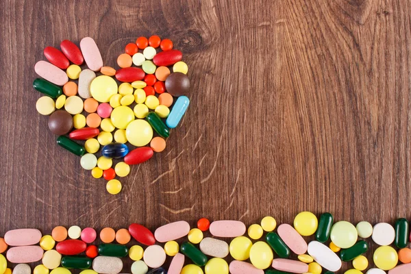 Heart shaped colorful medical pills and capsules, health care concept, copy space for text