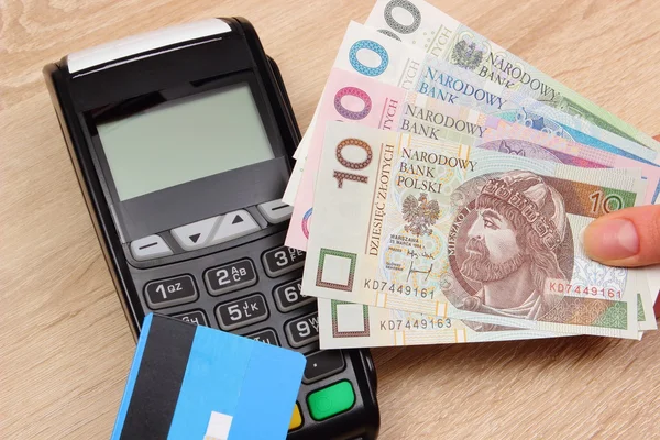 Polish currency money and credit card with payment terminal in background, finance concept