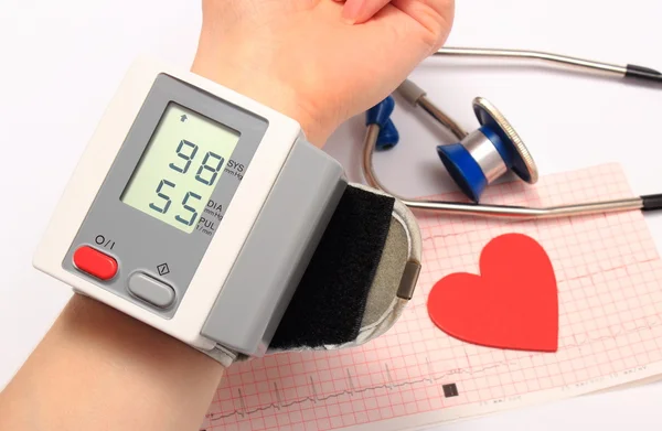 Measuring blood pressure, heart shape and stethoscope on electrocardiogram