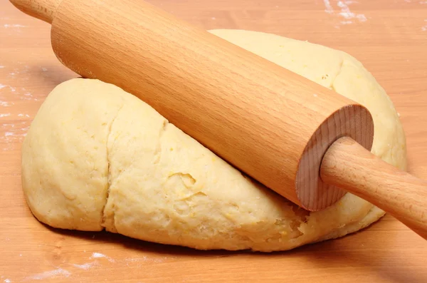 Yeast cake and rolling pin on wooden table