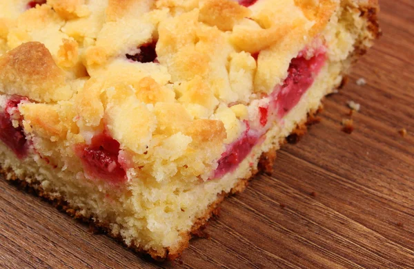 Fresh baked yeast cake with strawberries on wooden table