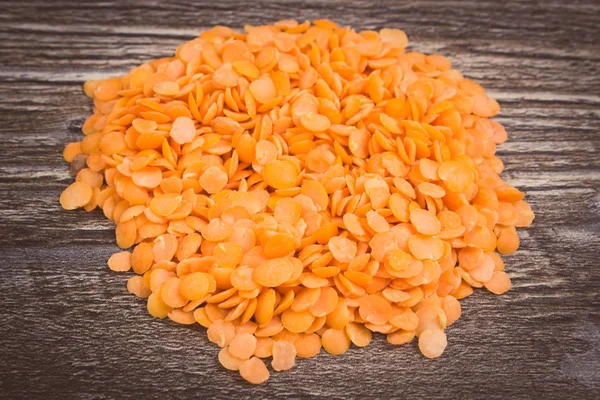 Vintage photo, Heap of red lentil on wooden background