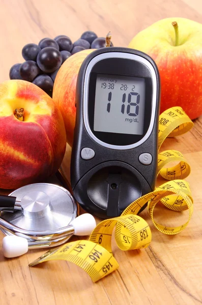 Glucose meter with medical stethoscope and fresh fruits, healthy lifestyle