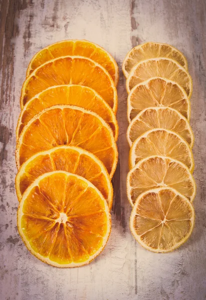Vintage photo, Slices of dried lemon and orange on old wooden background