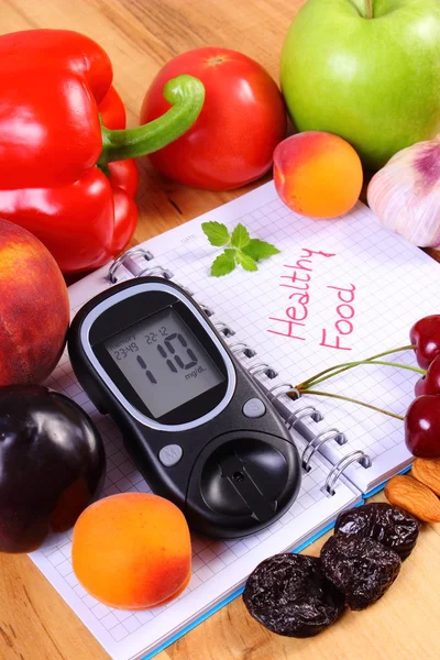 Fruits and vegetables with glucometer and notebook for notes, healthy food, diabetes