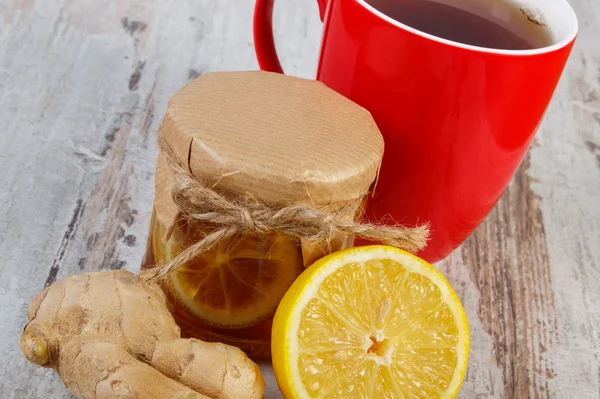 Lemon with honey, ginger and cup of tea on wooden table, healthy nutrition