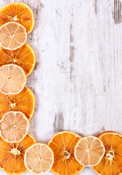 Slices of dried lemon and orange on old wooden background, copy space for text