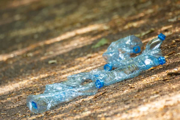 Plastic bottles of mineral water on path in park, littering of environment