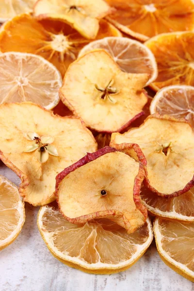 Slices of dried lemon, orange and apple on old wooden background