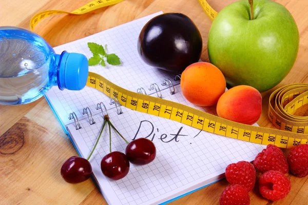 Fruits and centimeter with notebook, slimming and healthy food