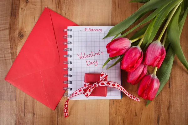 Valentines Day written in notebook, fresh tulips, love letter and gift, decoration for Valentines