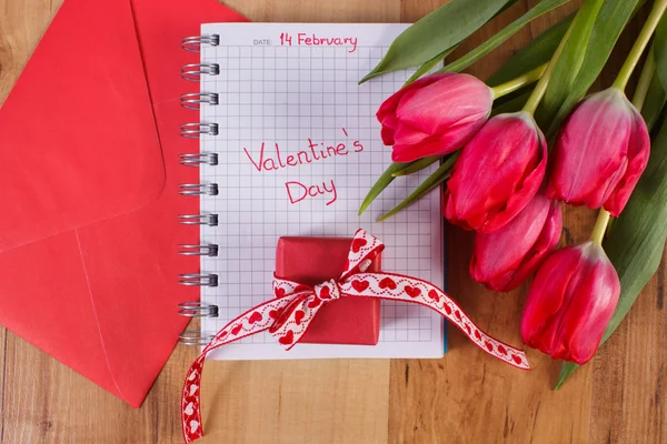 Valentines Day written in notebook, fresh tulips, love letter and gift, decoration for Valentines