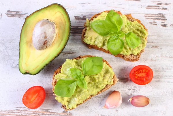 Freshly sandwiches with paste of avocado and ingredients, healthy food and nutrition