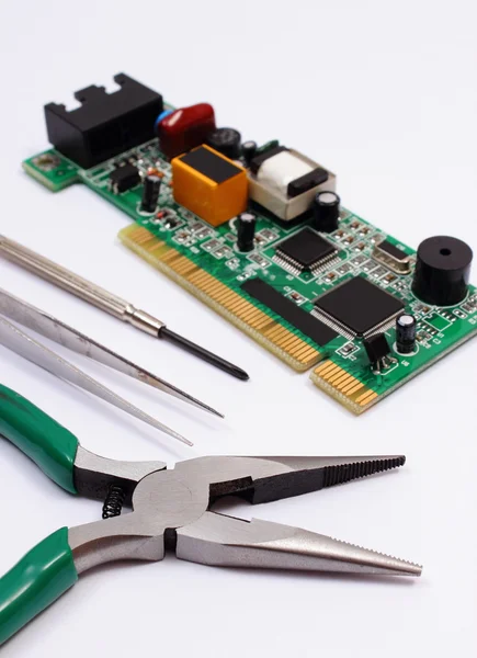 Printed circuit board and precision tools on white background, technology