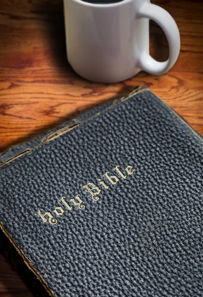 Closeup of Old Bible on Table With Coffee Mug Background