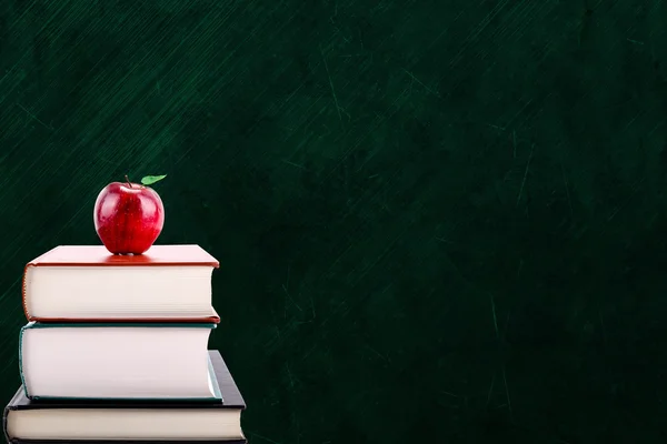 Education Concept With Apple on Books and Chalkboard Background