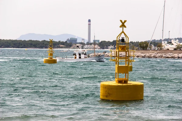 Yellow buoys and sailor boat