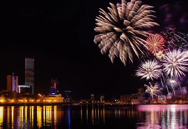 Colored flashes of fireworks over the city pond of Yekaterinburg in the city center