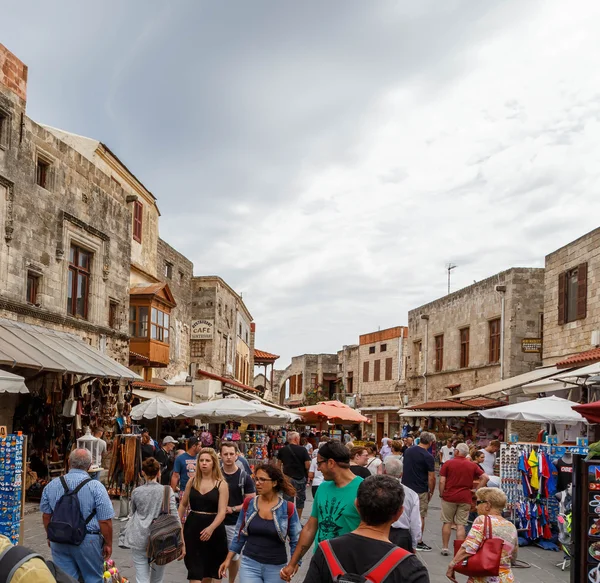 RHODOS, GREECE- JUNE 14 2016: Many tourists visiting and shopping at market street in old town Rhodos, Greece