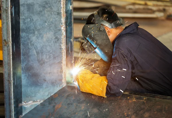 Worker welding construction by MIG welding