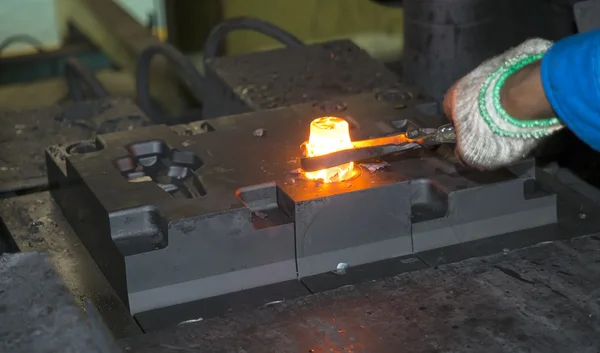 Operator forging automotive parts by hot forging