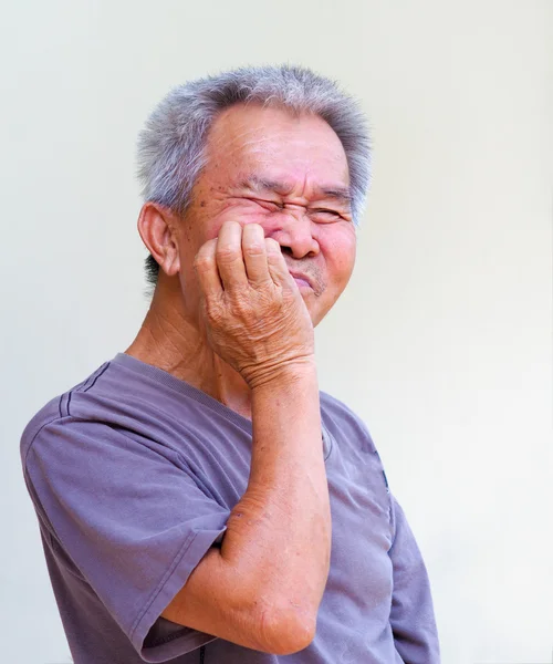 Old man use hand covered mouth pretending toothache.