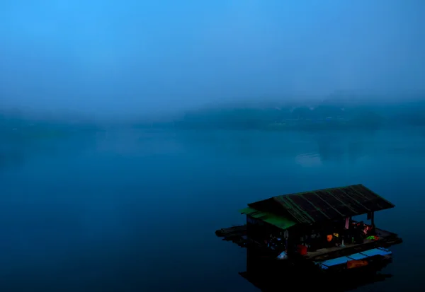 Boat on the lake at morning fog.