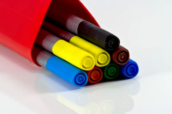 Colored sticks in a red box on a white table background.