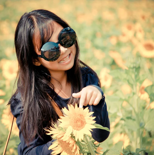 Young girl wear glasses smile to camera stand inside sunflower f