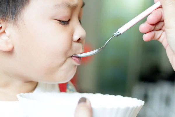 Close up of South East Asian Thai baby  being spoon fed : being