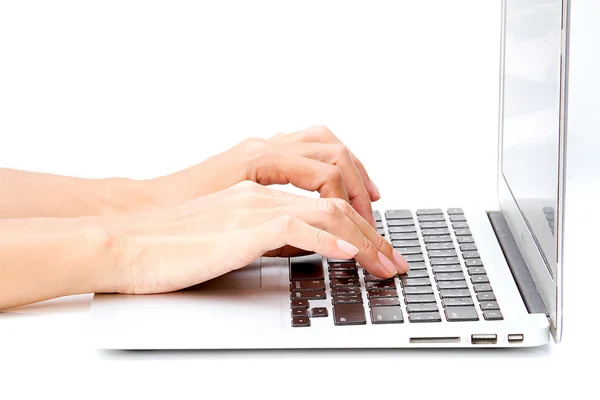 Woman hand typing on the laptop on white table