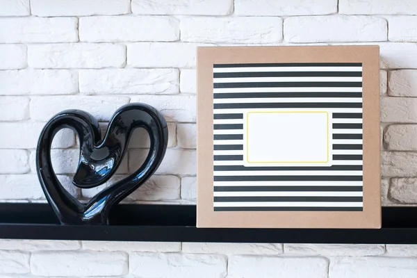 Present box on the shelf decorated black stripes and heart