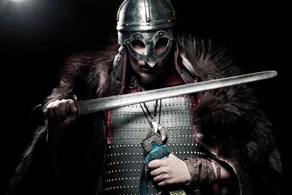Viking warrior, male dressed in Barbarian style with sword, bear