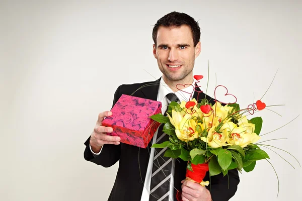 Businessman with gift and bouquet of orchids