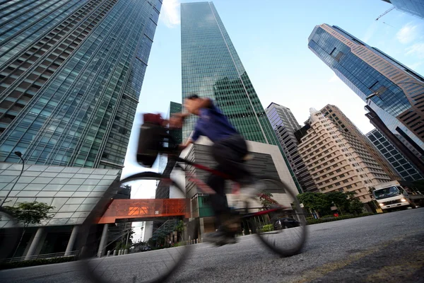 Man on bike with skyscrapers on background