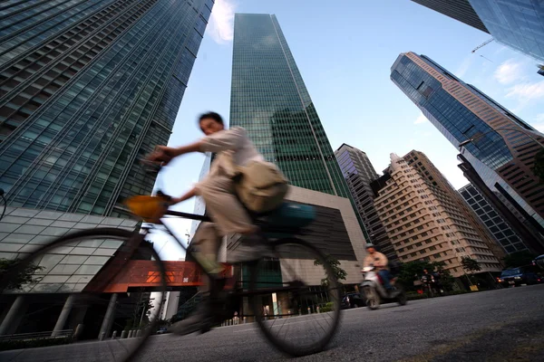 Man on bike with skyscrapers on background