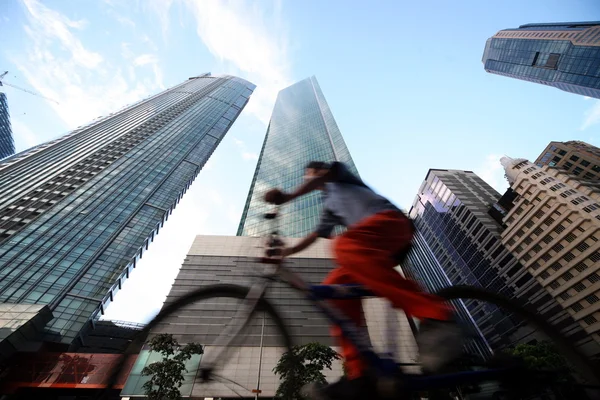 Man on bike with skyscrapers on background