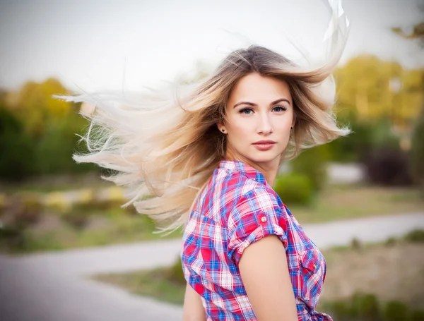 Wellness and spa. Sensual woman model with windswept flying dark blond hair on green background. Shiny long health hairstyle. Beauty and haircare. High fashion look.