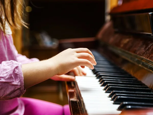 Little girl studing to play the piano