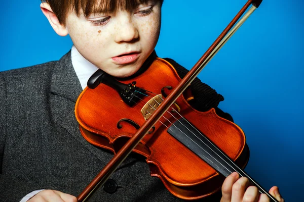 Red-haired preschooler boy with violin, music concept