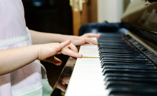 Girl\'s hands and piano keyboard close-up view