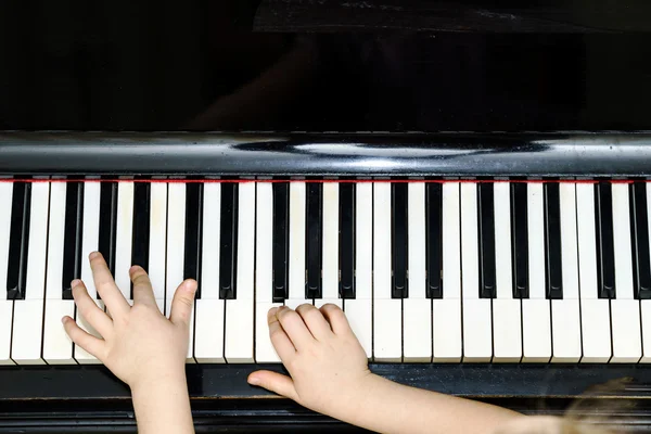 Girl\'s hands and piano keyboard close-up view