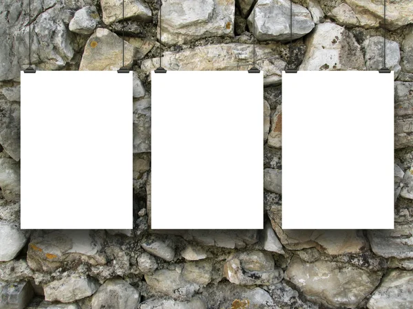 Three hanged empty sheets on irregular stone wall
