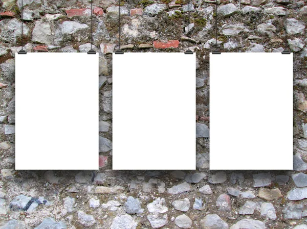 Three hanged paper sheets on medieval stone wall