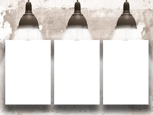 Three hanged paper sheets with vintage lamps on moulded concrete wall