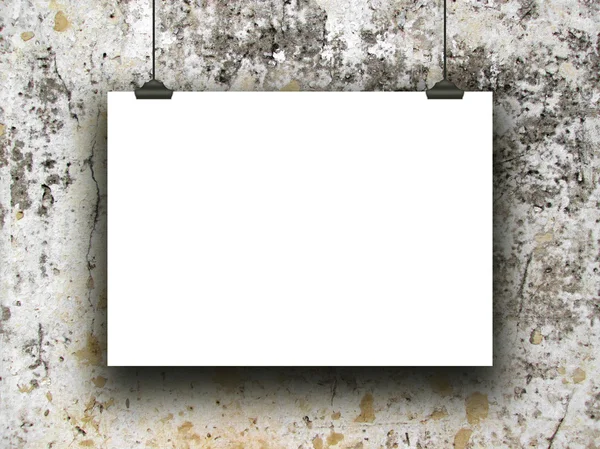 Single hanged horizontal paper sheet with clips on moulded and weathered concrete wall