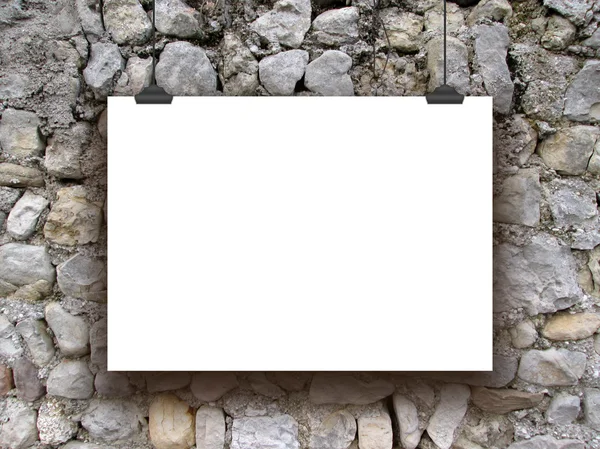 Single hanged horizontal paper sheet with clips on medieval stone wall