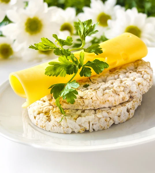 Rice cakes with cheese, parsley and flowers - healthy eating concept for springtime