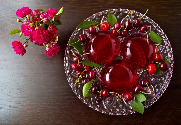 Summer refreshing dessert - red berries jelly with cherries on a dark background, selective focus
